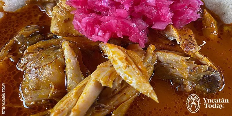 A plate of Pollo (chicken) Pibil, prepared with red recado and cooked underground.