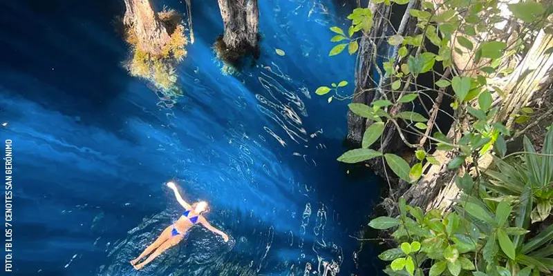 Mujer nadando en Cenote Mariposa, Los Siete Cenotes